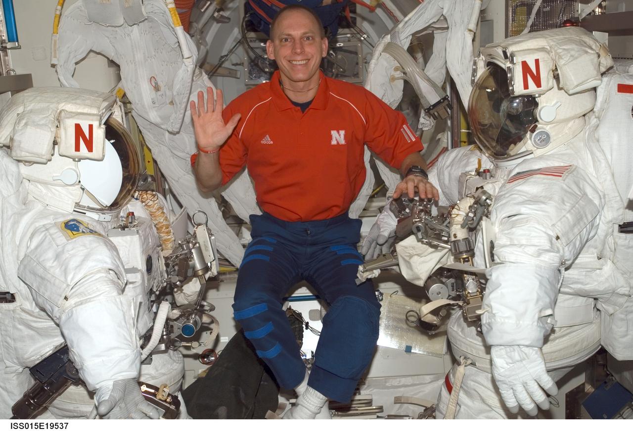 ISS015-E-19537 (19 July 2007) --- Astronaut Clay Anderson, Expedition 15 flight engineer, poses for a photo with two extravehicular mobility units (EMU) in the Quest Airlock of the International Space Station