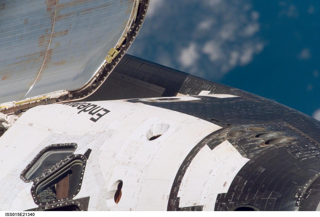 ISS015-E-21340 (10 Aug. 2007) --- This is one of a series of images photographed with a digital still camera using an 800mm focal length featuring the different areas of the Space Shuttle Endeavour as it approached the International Space Station and performed a back-flip to accommodate close scrutiny by eyeballs and cameras. This image shows part of the commander's side or port side of Endeavour's cabin, including the hatch, as well as a section of the open payload bay cover. Distance between the station and shuttle at this time was approximately 600 feet.