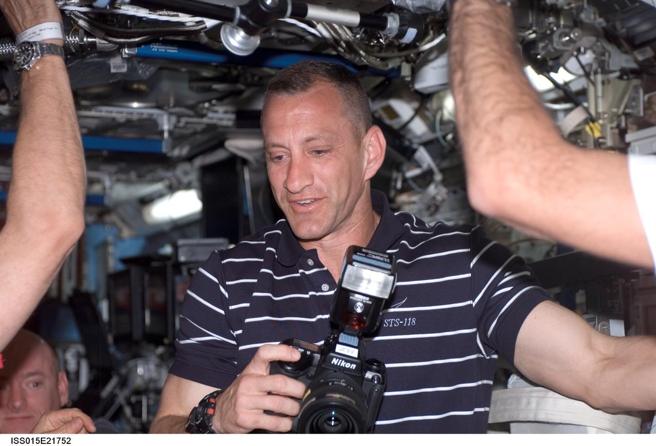 ISS015-E-21752 (10 Aug. 2007) --- Astronaut Charlie Hobaugh, STS-118 pilot, holds a camera in the Destiny laboratory of the International Space Station following the docking with the Space Shuttle Endeavour.