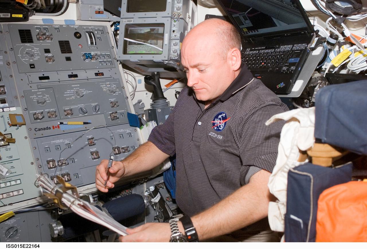ISS015-E-22164 (12 Aug. 2007) --- Astronaut Scott Kelly, STS-118 commander, looks over procedures checklists on the aft flight deck of Space Shuttle Endeavour while docked with the International Space Station.