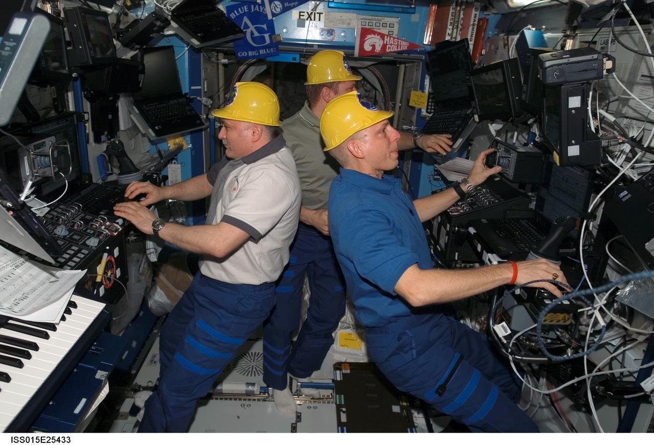 ISS015-E-25433 (30 Aug. 2007) --- Cosmonauts Fyodor N. Yurchikhin (left) and Oleg V. Kotov, Expedition 15 commander and flight engineer, respectively, both representing Russia's Federal Space Agency; along with astronaut Clay Anderson (right), flight engineer, work various tasks in the Destiny laboratory of the International Space Station during Pressurized Mating Adapter-3 (PMA-3) transfer operations. Using the station's robotic arm, Canadarm2, the PMA-3 was undocked from the Unity node's left side at 7:18 a.m. (CDT) and docked to Unity's lower port at 8:07 a.m. to prepare for the arrival of Node 2, the Harmony module, on the STS-120 flight of Space Shuttle Discovery in October 2007.