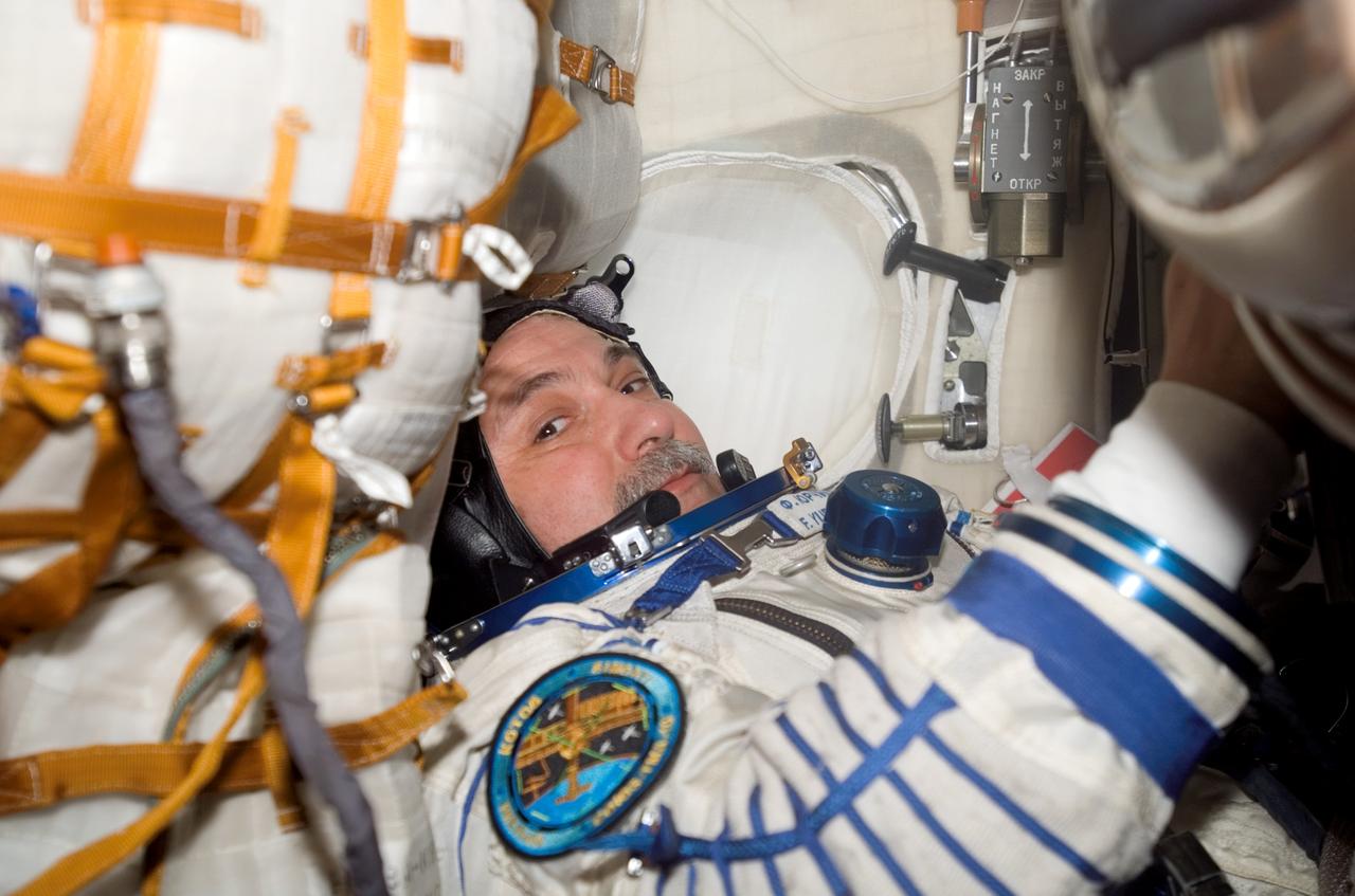 ISS015-E-31325 (27 Sept. 2007) --- Attired in a Russian Sokol launch and entry suit, cosmonaut Fyodor N. Yurchikhin, Expedition 15 commander representing Russia's Federal Space Agency, is seated in the Soyuz TMA-10 spacecraft docked to the International Space Station. The Expedition 15 crew undocked the Soyuz spacecraft from the nadir port of the Zarya module at 2:20 p.m. (CDT) and flew a short distance to the aft port of the Zvezda Service Module. Redocking occurred at 2:45 p.m. (CDT). The move was in preparation for the arrival of the new Soyuz TMA-11 capsule on Oct. 12, carrying the Expedition 16 crew and a Malaysian spaceflight participant.