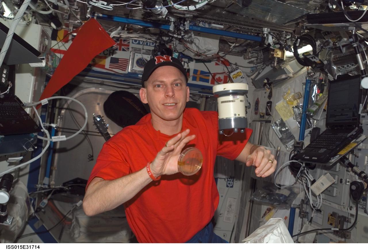 ISS015-E-31714 (3 Oct. 2007) --- NASA astronaut Clay Anderson, Expedition 15 flight engineer, poses with a microbial air sampler (MAS) and petri dish in the Destiny laboratory of the International Space Station.