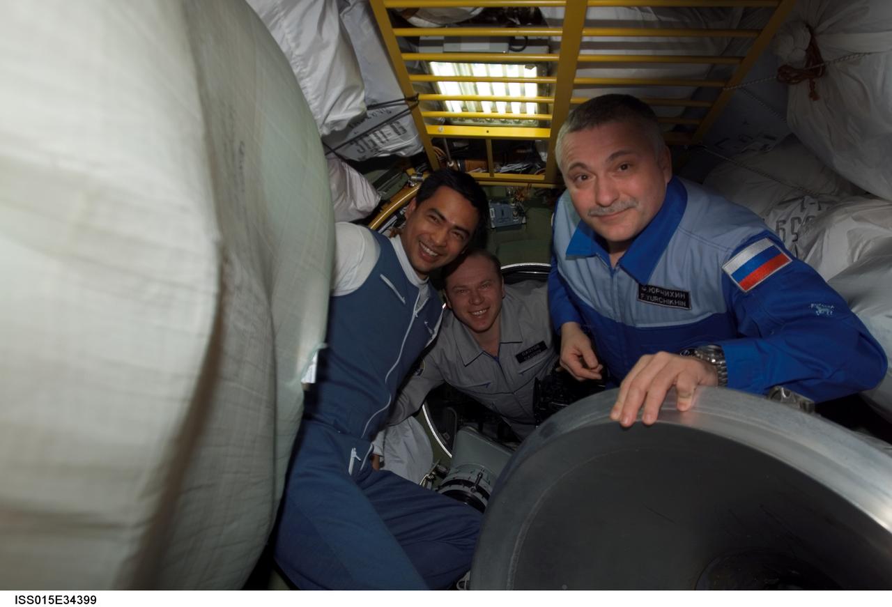 ISS015-E-34399 (12 Oct. 2007) --- Malaysian spaceflight participant Sheikh Muszaphar Shukor (left) shares his first moments on the International Space Station  with  Expedition 15 crewmembers Oleg Kotov (center) and Fyodor Yurchikhin, flight engineer and commander, respectively, both with Russia's Federal Space Agency.  The three are in the Zvezda Service Module.  Sheikh Shukor arrived at the space station onboard a Soyuz spacecraft with two Expedition 16 crewmembers.