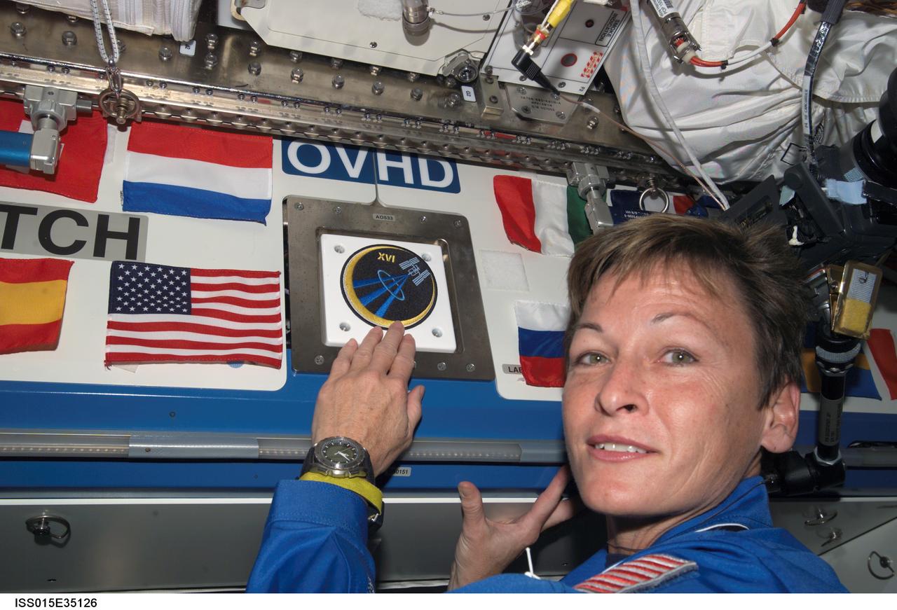 ISS015-E-35126 (19 Oct. 2007) --- NASA astronaut Peggy A. Whitson, Expedition 16 commander, places the Expedition 16 patch above a hatch in the Destiny laboratory, which adds to the growing collection of insignias representing crews who have lived and worked on the International Space Station.