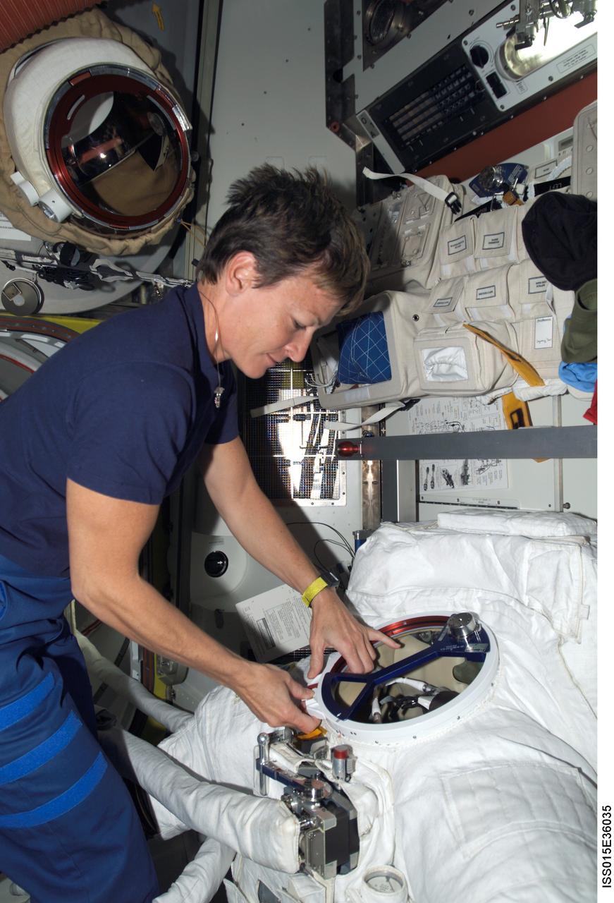 ISS015-E-36035 (17 Oct. 2007) --- NASA astronaut Peggy A. Whitson, Expedition 16 commander, works with an Extravehicular Mobility Unit (EMU) spacesuit in the Quest Airlock of the International Space Station. Whitson and cosmonaut Yuri I. Malenchenko (out of frame), flight engineer representing Russia's Federal Space Agency, are scheduled to perform the fifth session of extravehicular activity (EVA) while Discovery is docked with the station.
