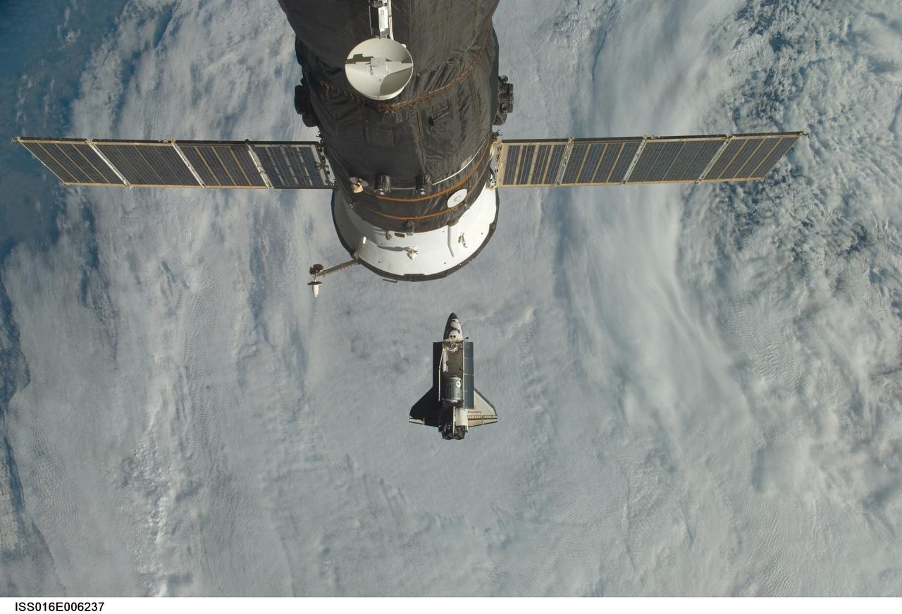 ISS016-E-006237 (25 Oct. 2007) --- Backdropped by a cloud-covered part of Earth, Space Shuttle Discovery (STS-120) approaches the International Space Station during STS-120 rendezvous and docking operations. Docking occurred at 7:40 a.m. (CDT) on Oct. 25, 2007, as the two spacecraft flew over the Atlantic Ocean just off the coast of North Carolina. The Harmony node is visible in Discovery's cargo bay. A Russian spacecraft, docked to the station, is visible in the foreground.