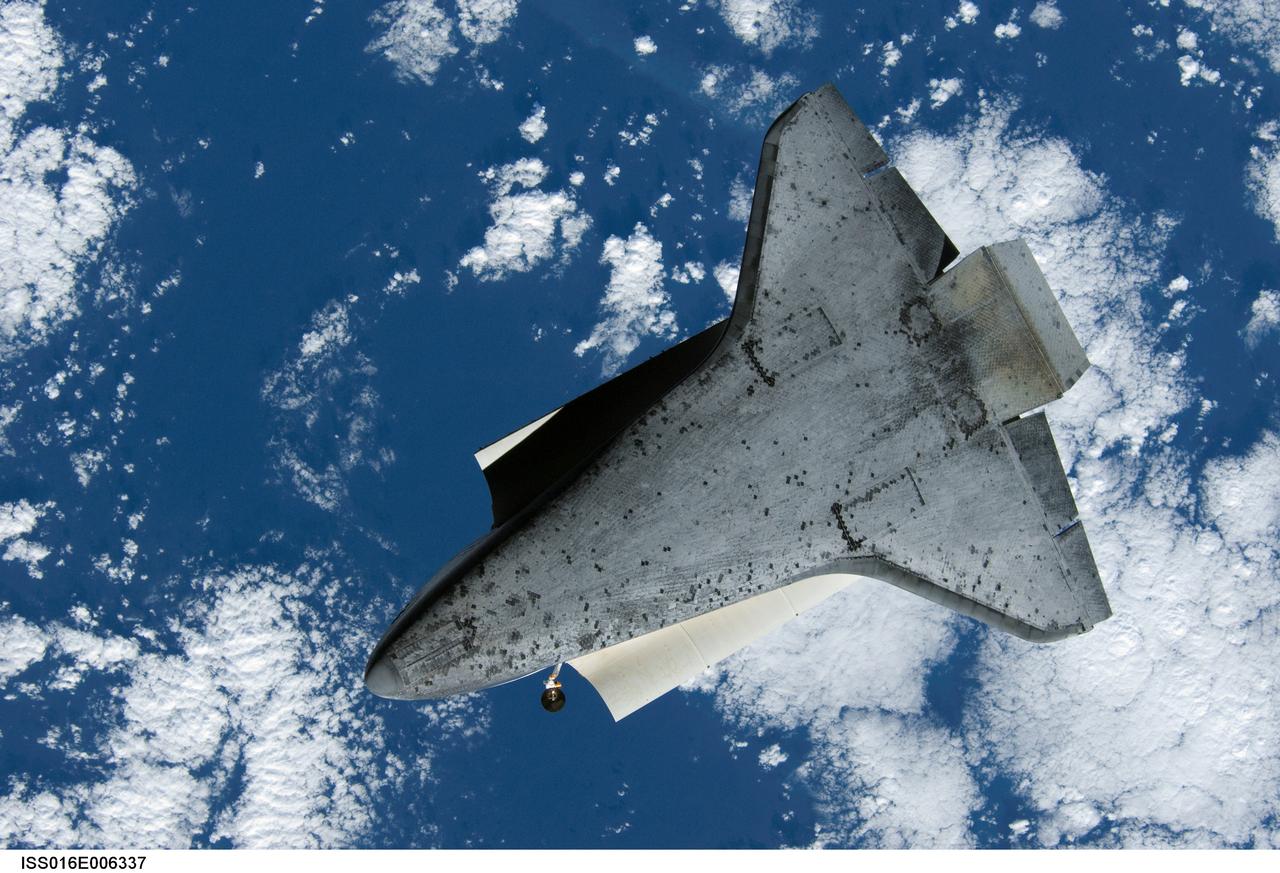 ISS016-E-006337 (25 Oct. 2007) --- Backdropped by a blue and white Earth, the underside of the Space Shuttle Discovery is featured in this image photographed by an Expedition 16 crewmember during a backflip maneuver performed by the approaching visitors (STS-120) to the International Space Station.