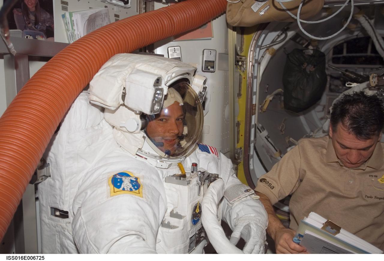 ISS016-E-006725 (26 Oct. 2007) --- Attired in his Extravehicular Mobility Unit (EMU) spacesuit, astronaut Doug Wheelock, STS-120 mission specialist, prepares for the mission's first session of extravehicular activity (EVA) in the Quest Airlock of the International Space Station while Space Shuttle Discovery is docked with the station. European Space Agency (ESA) astronaut Paolo Nespoli, mission specialist, assisted Wheelock.