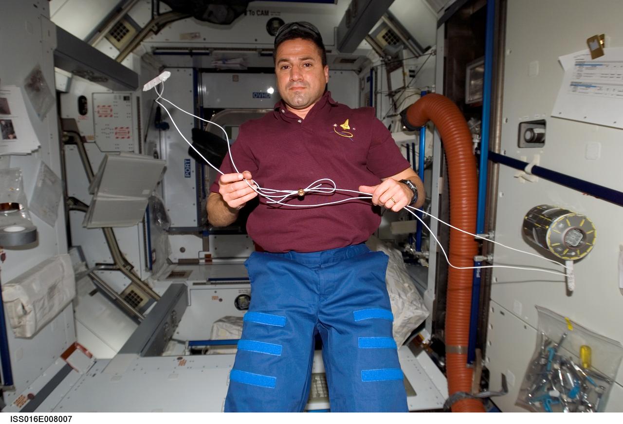 ISS016-E-008007 (1 Nov. 2007) --- Astronaut George Zamka, STS-120 pilot, holds a "cufflink" apparatus in the Harmony node of the International Space Station, which will be attached to the damaged solar arrays and take the structural load off of the broken hinge during the next spacewalk while Space Shuttle Discovery is docked with the station.