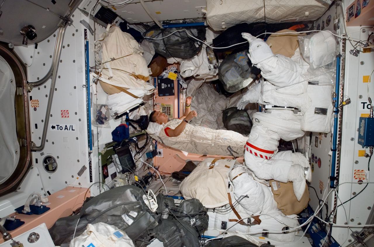 ISS016-E-008034 (2 Nov. 2007) --- Astronaut Daniel Tani, Expedition 16 flight engineer, sleeps in his sleeping bag in the Unity node of the International Space Station while Space Shuttle Discovery is docked with the station.