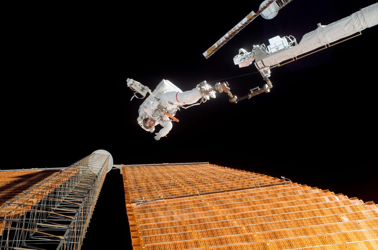 ISS016-E-008937 (3 Nov. 2007) --- While anchored to a foot restraint on the end of the Orbiter Boom Sensor System (OBSS), astronaut Scott Parazynski, STS-120 mission specialist, assesses his repair work as the solar array is fully deployed during the mission's fourth session of extravehicular activity (EVA) while Space Shuttle Discovery is docked with the International Space Station. During the 7-hour, 19-minute spacewalk, Parazynski cut a snagged wire and installed homemade stabilizers designed to strengthen the damaged solar array's structure and stability in the vicinity of the damage. Astronaut Doug Wheelock (out of frame), mission specialist, assisted from the truss by keeping an eye on the distance between Parazynski and the array.