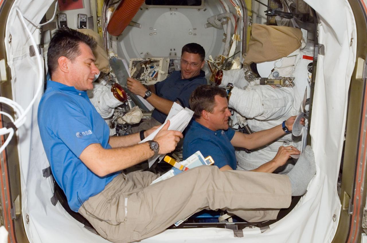 ISS016-E-008971 (2 Nov. 2007) --- Astronauts Paolo Nespoli (foreground) representing the European Space Agency (ESA), Scott Parazynski (right) and Doug Wheelock, all STS-120 mission specialists, make preparations for the mission's fourth spacewalk in the Quest Airlock of the International Space Station while Space Shuttle Discovery is docked with the station.