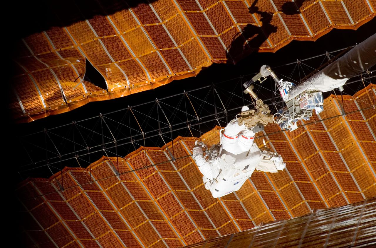 ISS016-E-009184 (3 Nov. 2007) --- While anchored to a foot restraint on the end of the Orbiter Boom Sensor System (OBSS), astronaut Scott Parazynski, STS-120 mission specialist, participates in the mission's fourth session of extravehicular activity (EVA) while Space Shuttle Discovery is docked with the International Space Station. During the 7-hour, 19-minute spacewalk, Parazynski cut a snagged wire and installed homemade stabilizers designed to strengthen the damaged solar array's structure and stability in the vicinity of the damage. Astronaut Doug Wheelock (out of frame), mission specialist, assisted from the truss by keeping an eye on the distance between Parazynski and the array. Once the repair was complete, flight controllers on the ground successfully completed the deployment of the array.