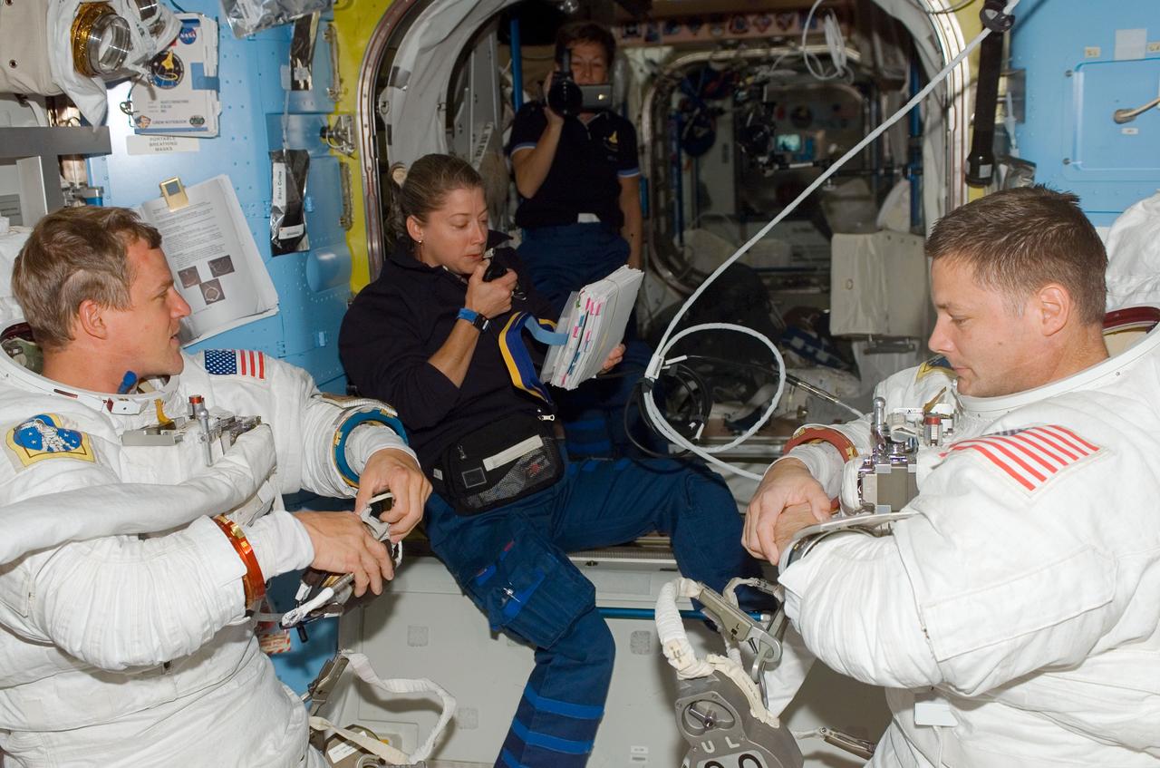 ISS016-E-009233 (3 Nov. 2007) --- Attired in their Extravehicular Mobility Unit (EMU) spacesuits, astronauts Scott Parazynski (left) and Doug Wheelock, STS-120 mission specialists; are pictured in the Quest Airlock of the International Space Station as the mission's fourth spacewalk draws to a close. Also pictured are astronauts Pam Melroy (center foreground), STS-120 commander, and Peggy Whitson, Expedition 16 commander.