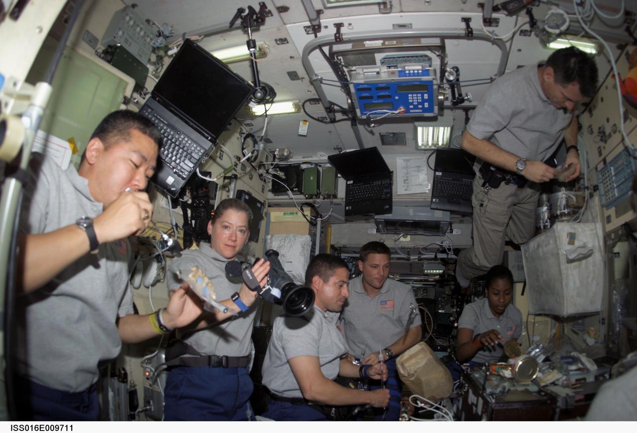 ISS016-E-009711 (4 Nov. 2007) --- STS-120 and Expedition 16 crewmembers share a meal in the Zvezda Service Module of the International Space Station while Space Shuttle Discovery is docked with the station. Pictured (from the left) are astronauts Daniel Tani, Expedition 16 flight engineer; Pam Melroy, STS-120 commander; George Zamka, pilot; Doug Wheelock, Stephanie Wilson and European Space Agency's (ESA) Paolo Nespoli, all mission specialists.