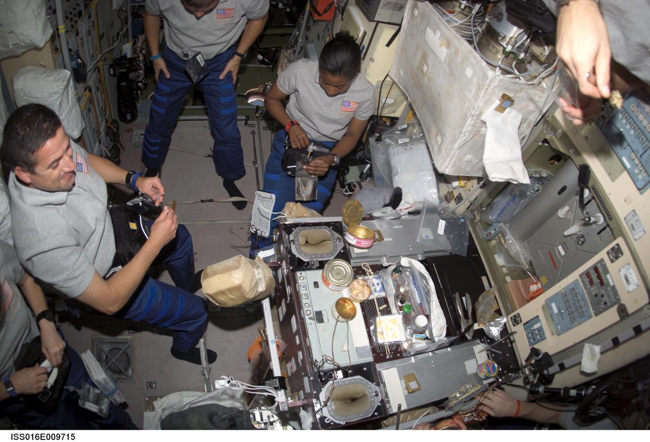 ISS016-E-009715 (4 Nov. 2007) --- The crewmembers onboard the International Space Station share a meal in the Zvezda Service Module while Space Shuttle Discovery is docked with the station. Pictured are astronauts George Zamka (left), STS-120 pilot; Doug Wheelock (partially out of frame) and Stephanie Wilson, both mission specialists.