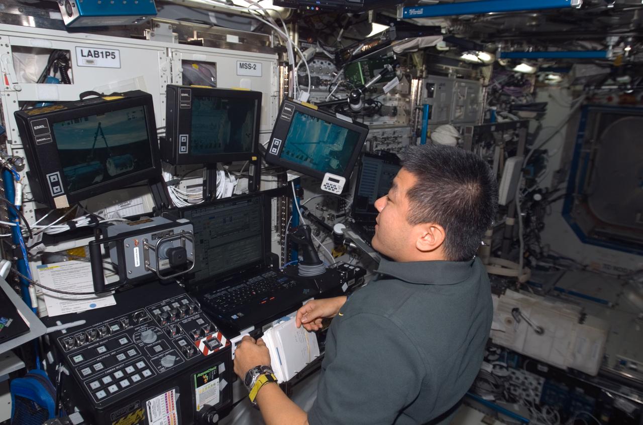 ISS016-E-011253 (14 Nov. 2007) --- Astronaut Daniel Tani, Expedition 16 flight engineer, works the controls of the space station's robotic Canadarm2 in the Destiny laboratory of the International Space Station, during the relocation of the Harmony node and Pressurized Mating Adapter 2 (PMA2) from the Unity node to the front of Destiny.