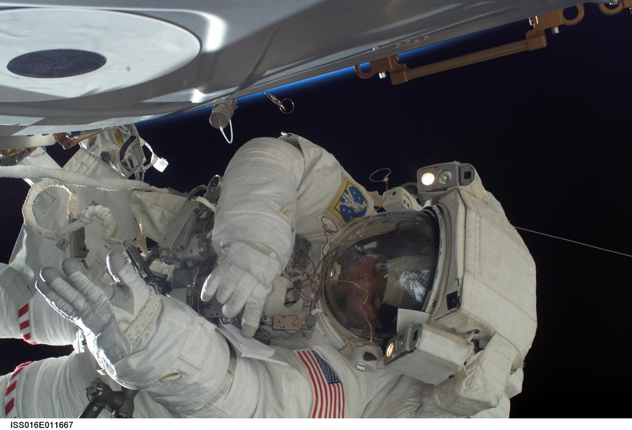 ISS016-E-011667 (20 Nov. 2007) --- Astronaut Daniel Tani, Expedition 16 flight engineer, checks notes on his sleeve during a Nov. 20 spacewalk on the International Space Station. Astronaut Peggy Whitson (out of frame), Expedition 16 commander, also participated in the spacewalk.