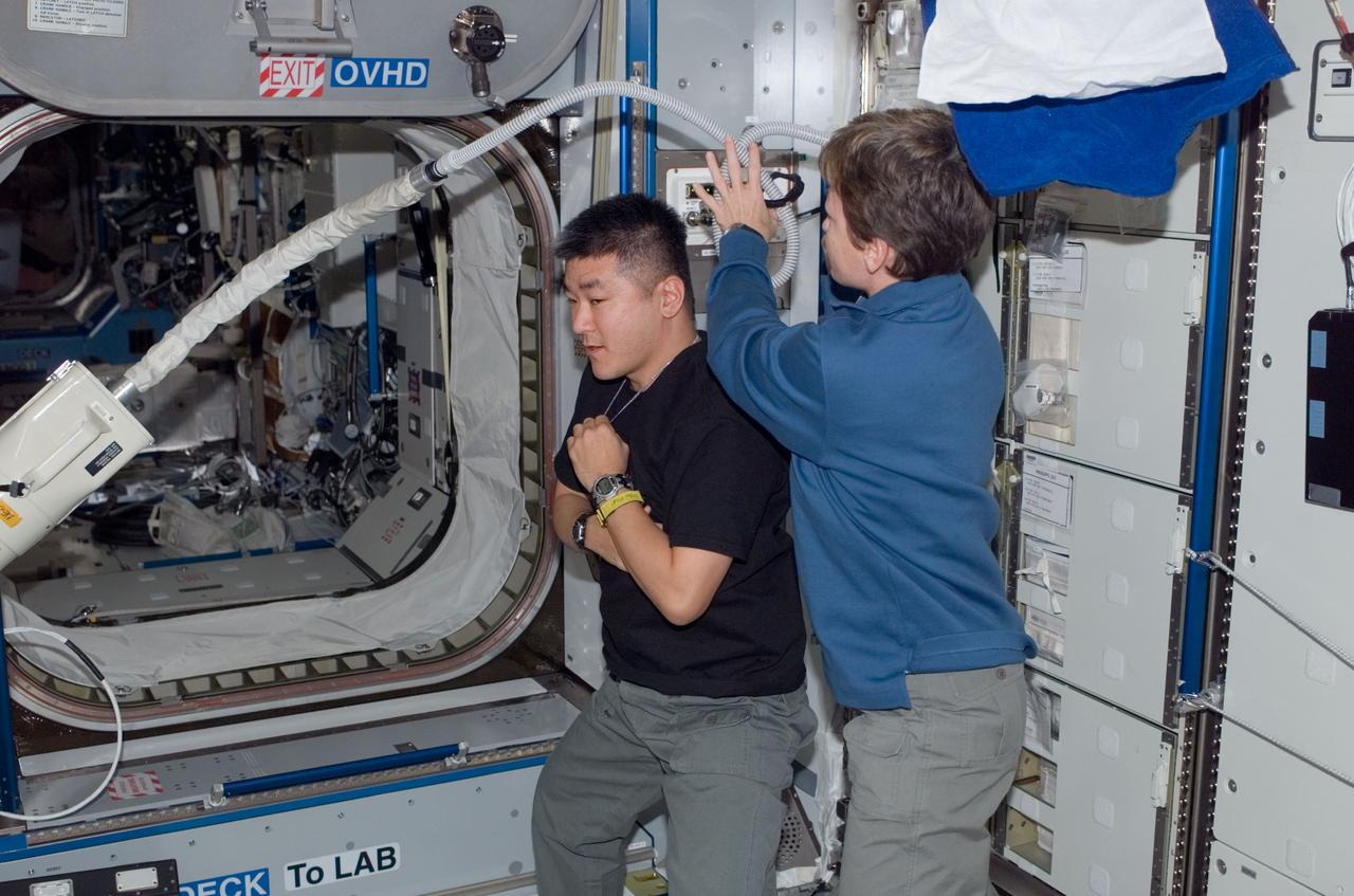 ISS016-E-014192 (1 Dec. 2007) --- Astronaut Peggy A. Whitson, Expedition 16 commander, trims astronaut Daniel Tani's hair in the Harmony node of the International Space Station. Whitson used hair clippers fashioned with a vacuum device to garner freshly cut hair.
