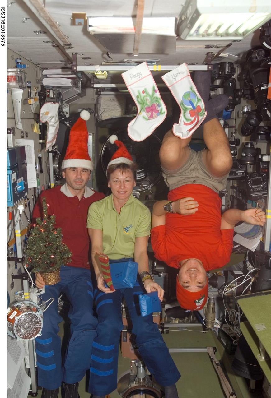 ISS016-E-018575 (25 Dec. 2007) --- The Expedition 16 crewmembers pose for a Christmas photo in the Zvezda Service Module of the International Space Station. From the left are cosmonaut Yuri I. Malenchenko, flight engineer representing Russia's Federal Space Agency; NASA astronauts Peggy A. Whitson, commander; and Daniel Tani, flight engineer.