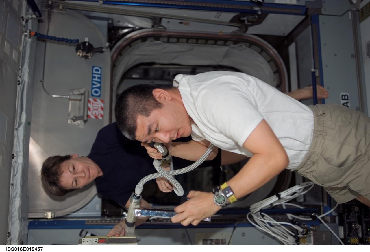 ISS016-E-019457 (30 Dec. 2007) --- Astronaut Daniel Tani, Expedition 16 flight engineer, trims his hair in the Harmony node of the International Space Station. Tani used hair clippers fashioned with a vacuum device to garner freshly cut hair. Astronaut Peggy Whitson, commander, assisted Tani.