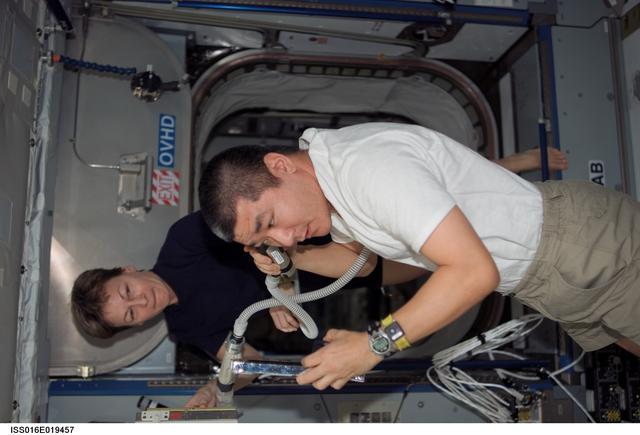 NASA image: Whitson gives Tani a haircut in Node 2