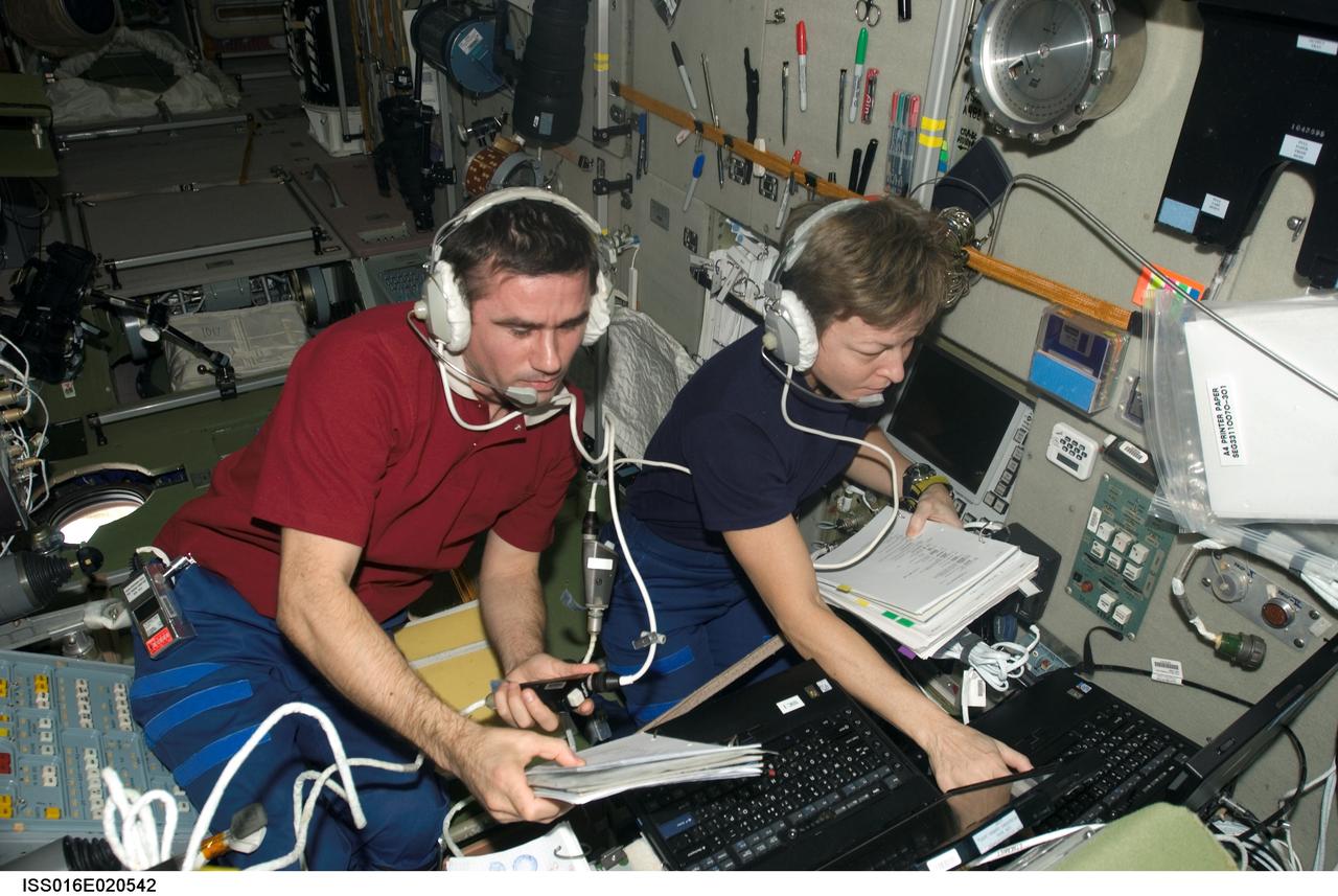 ISS016-E-020542 (26 Dec. 2007) --- NASA astronaut Peggy A. Whitson (right), Expedition 16 commander, and cosmonaut Yuri I. Malenchenko, flight engineer representing Russia's Federal Space Agency, work in tandem in the Zvezda Service Module of the International Space Station during the rendezvous and docking of the unpiloted Progress 27 spacecraft.