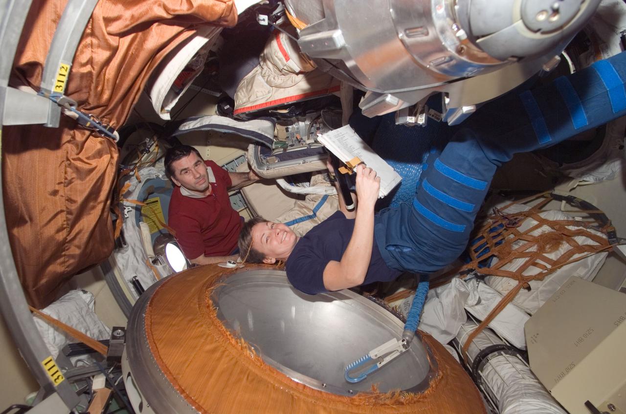 ISS016-E-021932 (8 Jan. 2008) --- NASA astronaut Peggy A. Whitson, Expedition 16 commander; and cosmonaut Yuri I. Malenchenko, flight engineer representing Russia's Federal Space Agency, work in the Pirs Docking Compartment of the International Space Station.