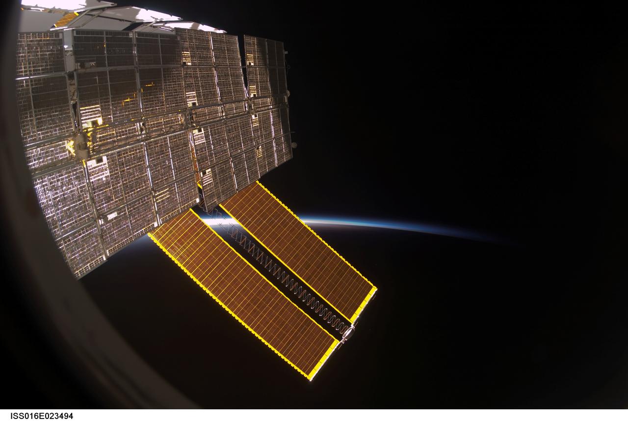 View of Solar Arrays through a Window on the ISS