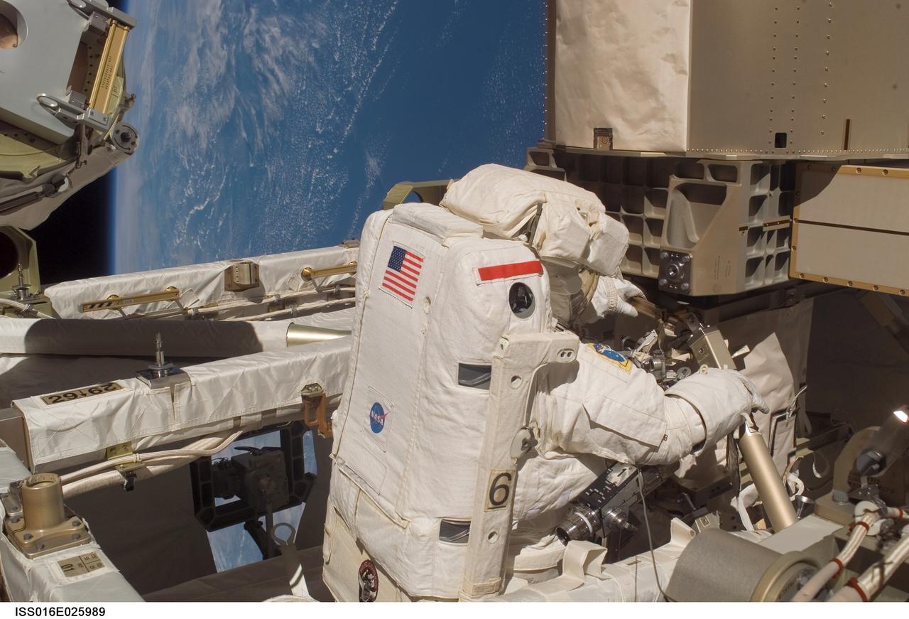 ISS016-E-025989 (30 Jan. 2008) --- Astronaut Peggy Whitson, Expedition 16 commander, participates in a session of extravehicular activity (EVA) as maintenance and construction continue on the International Space Station. During the 7-hour, 10-minute spacewalk, Whitson and astronaut Daniel Tani (out of frame), flight engineer, replaced a motor, known as the Bearing Motor Roll Ring Module (BMRRM), at the base of one of the station's solar wings. The BMRRM is part of the Beta Gimbal Assembly, which experienced electrical failures Dec. 8. A blue and white Earth provides the backdrop for the scene.