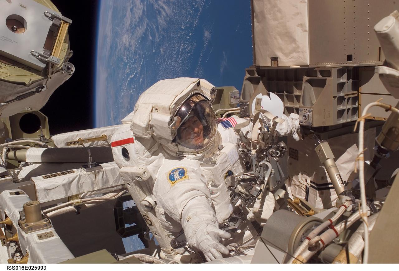 ISS016-E-025993 (30 Jan. 2008) --- Astronaut Peggy Whitson, Expedition 16 commander, participates in a session of extravehicular activity (EVA) as maintenance and construction continue on the International Space Station. During the 7-hour, 10-minute spacewalk, Whitson and astronaut Daniel Tani (out of frame), flight engineer, replaced a motor, known as the Bearing Motor Roll Ring Module (BMRRM), at the base of one of the station's solar wings. The BMRRM is part of the Beta Gimbal Assembly, which experienced electrical failures Dec. 8. A blue and white Earth and the blackness of space provide the backdrop for the scene.