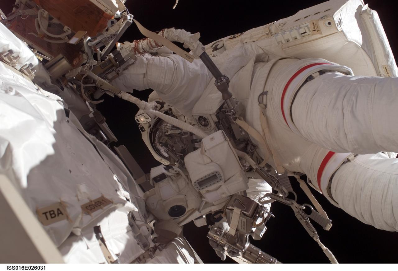 ISS016-E-026031 (30 Jan. 2008) --- Astronaut Peggy Whitson, Expedition 16 commander, participates in a session of extravehicular activity (EVA) as maintenance and construction continue on the International Space Station. During the 7-hour, 10-minute spacewalk, Whitson and astronaut Daniel Tani (out of frame), flight engineer, replaced a motor, known as the Bearing Motor Roll Ring Module (BMRRM), at the base of one of the station's solar wings. The BMRRM is part of the Beta Gimbal Assembly, which experienced electrical failures Dec. 8. A blue and white Earth and the blackness of space provide the backdrop for the scene.