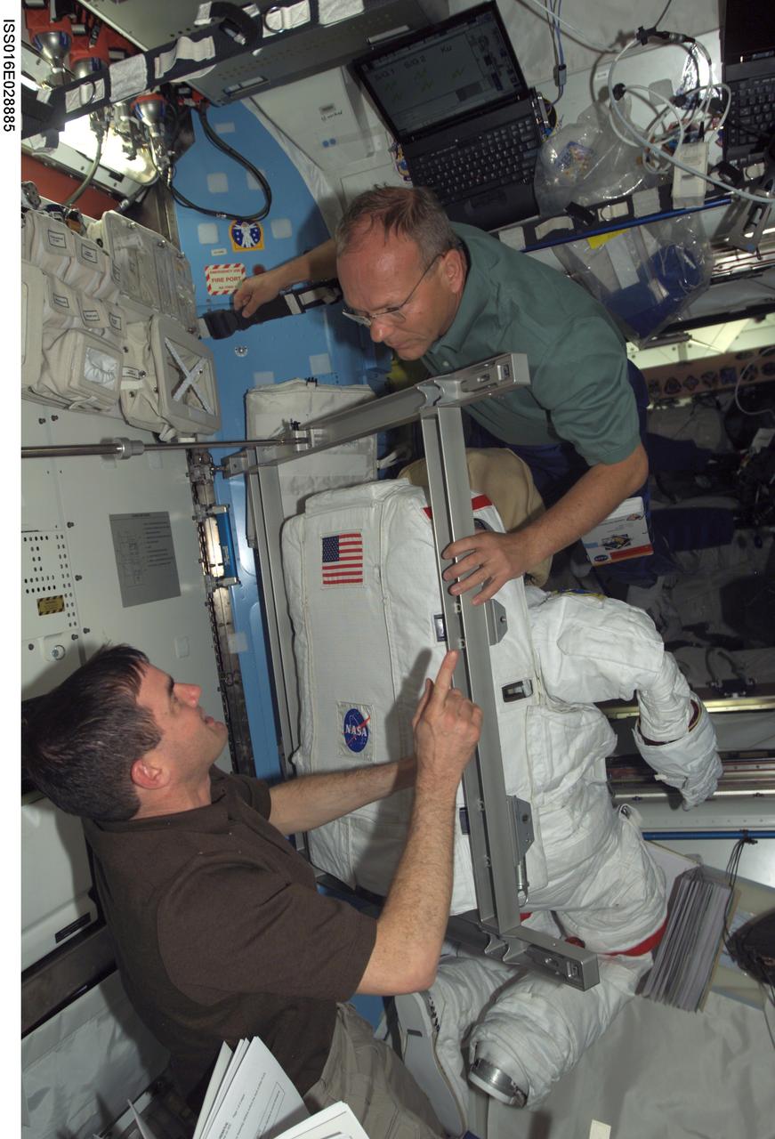 ISS016-E-028885 (9 Feb. 2008) --- NASA astronaut Rex Walheim (left) and European Space Agency (ESA) astronaut Hans Schlegel, both STS-122 mission specialists, work with Extravehicular Mobility Unit (EMU) spacesuits in the Quest Airlock of the International Space Station while Space Shuttle Atlantis is docked with the station.