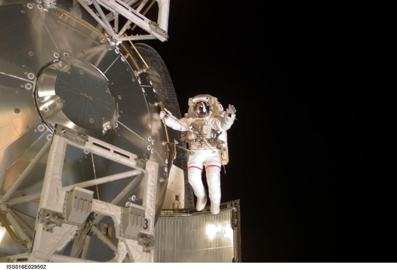 ISS016-E-029502 (15 Feb. 2008) --- Astronaut Rex Walheim, mission specialist, holds onto a handrail and spreads his arms at the Columbus laboratory, the newest piece of hardware on the International Space Station. On this the final spacewalk for the STS-122 Atlantis crew, Walheim's pose is reminiscent of that of a musical conductor who has just completed leading a successful concert. Stanley Love (out of frame), mission specialist, shared this extravehicular activity with Walheim.