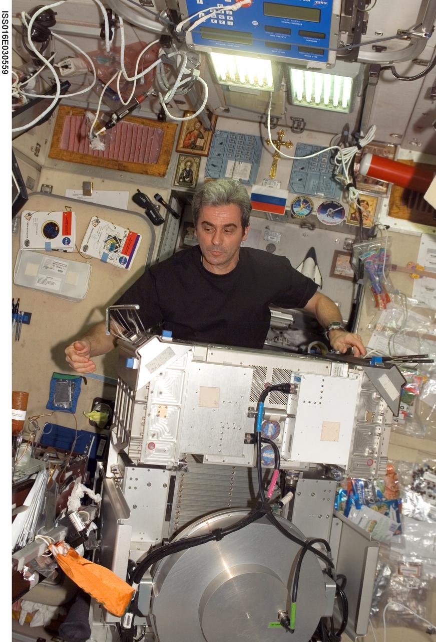 ISS016-E-030559 (4 March 2008) --- European Space Agency (ESA) astronaut Leopold Eyharts, Expedition 16 flight engineer, works with the Treadmill Vibration Isolation System (TVIS) removed from the Zvezda Service Module floor during in-flight maintenance (IFM) on the International Space Station.