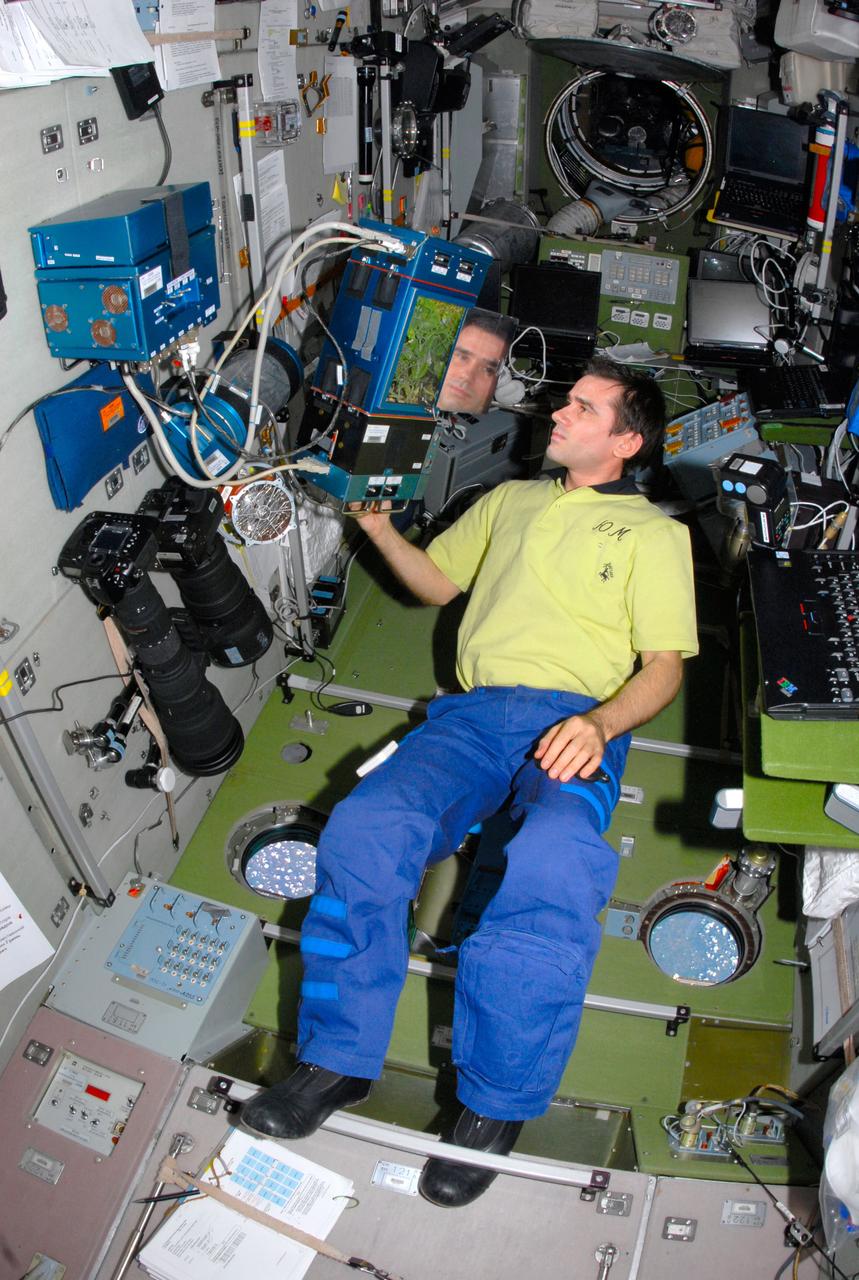 ISS016-E-031242 (6 March 2008) --- Cosmonaut Yuri I. Malenchenko, Expedition 16 flight engineer representing Russia's Federal Space Agency, checks the progress of pea plants growing in the Russian Lada greenhouse in the Zvezda Service Module of the International Space Station.