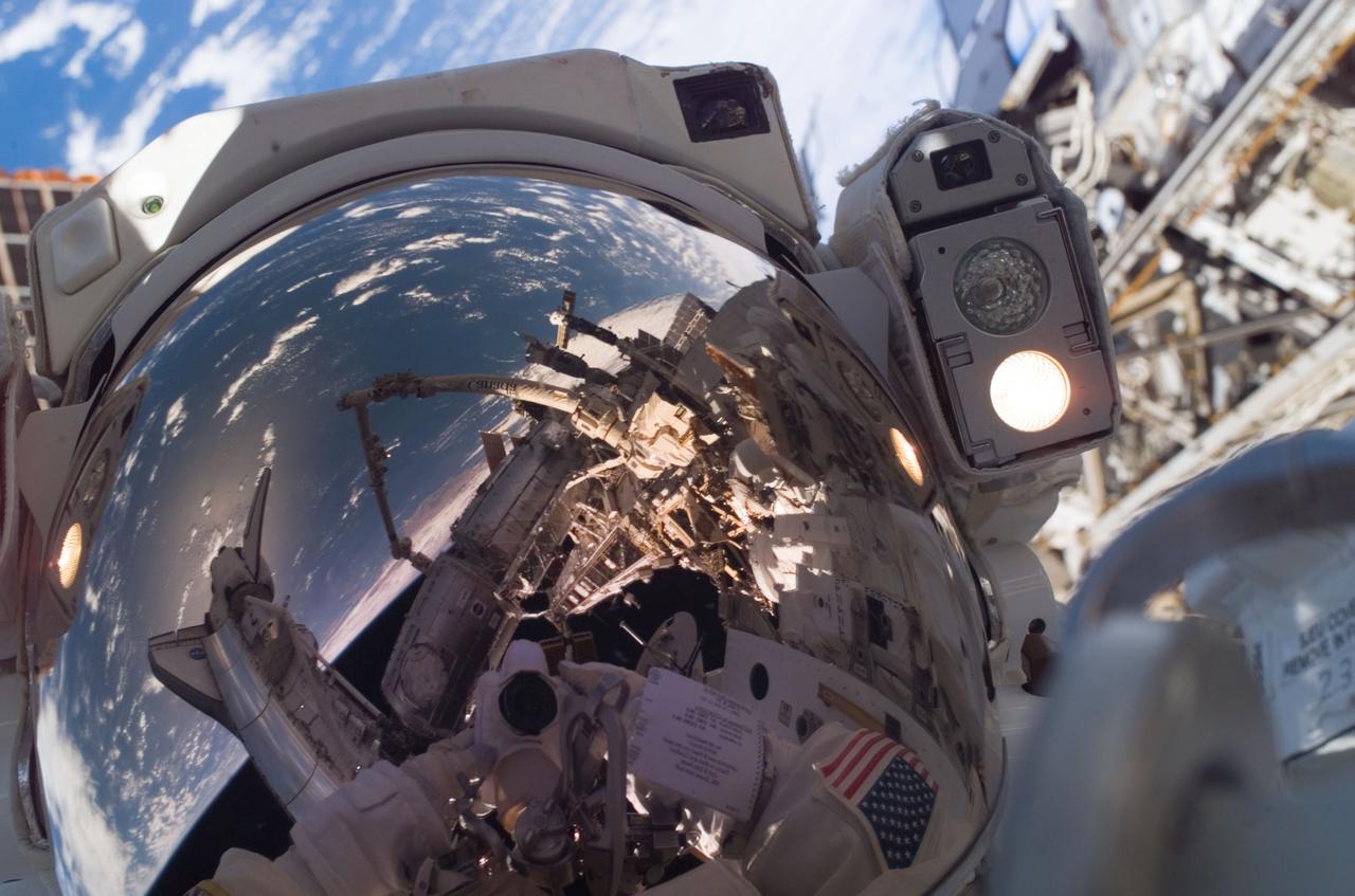 ISS016-E-032705 (13/14 March 2008) --- Astronaut Garrett Reisman, Expedition 16 flight engineer, uses a digital camera to expose a photo of his helmet visor during the mission's first scheduled session of extravehicular activity (EVA) as construction and maintenance continue on the International Space Station. Also visible in the reflections in the visor are various components of the station, the docked Space Shuttle Endeavour and a blue and white portion of Earth. During the seven-hour and one-minute spacewalk, Reisman and astronaut Rick Linnehan (out of frame), STS-123 mission specialist, prepared the Japanese logistics module-pressurized section (JLP) for removal from Space Shuttle Endeavour's payload bay; opened the Centerline Berthing Camera System on top of the Harmony module; removed the Passive Common Berthing Mechanism and installed both the Orbital Replacement Unit (ORU) tool change out mechanisms on the Canadian-built Dextre robotic system, the final element of the station's Mobile Servicing System.
