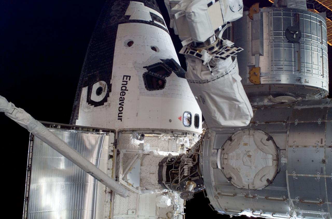 ISS016-E-032993 (18 March 2008) --- Space Shuttle Endeavour, docked to the Pressurized Mating Adapter (PMA-2) on the International Space Station, is featured in this image photographed by a crewmember during the STS-123 mission's third planned session of extravehicular activity (EVA). The newly installed Japanese Logistics Module - Pressurized Section (JLP) is visible at top right. The JLP is the first pressurized component of the Japan Aerospace Exploration Agency's Kibo laboratory and the newest component of the station.