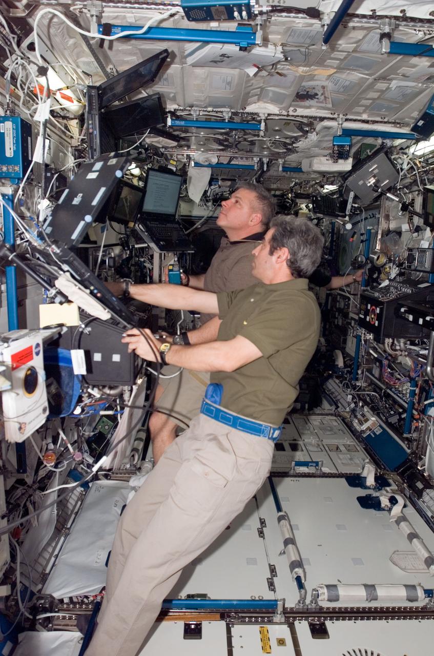 ISS016-E-033637 (23 March 2008) --- European Space Agency astronaut Leopold Eyharts, STS-123 mission specialist, and astronaut Gregory H. Johnson, pilot, perform work at the robotics work station in the U.S. laboratory, Destiny.