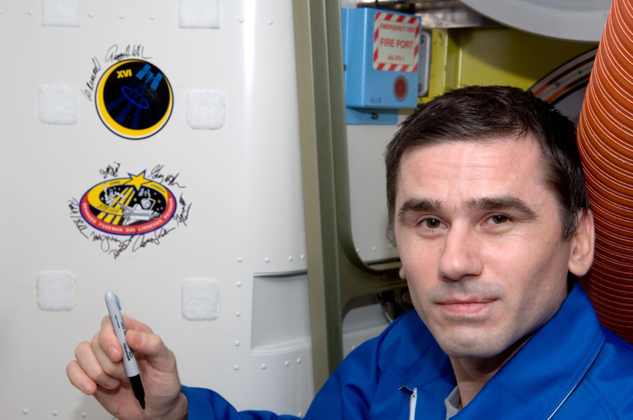 ISS016-E-036382 (17 April 2008) --- Russian Federal Space Agency cosmonaut Yuri Malenchenko, Expedition 16 flight engineer, poses for a photo after signing the Expedition 16 patch, which was added to the growing collection of insignias representing crews who performed spacewalks from the Quest Airlock of the International Space Station.