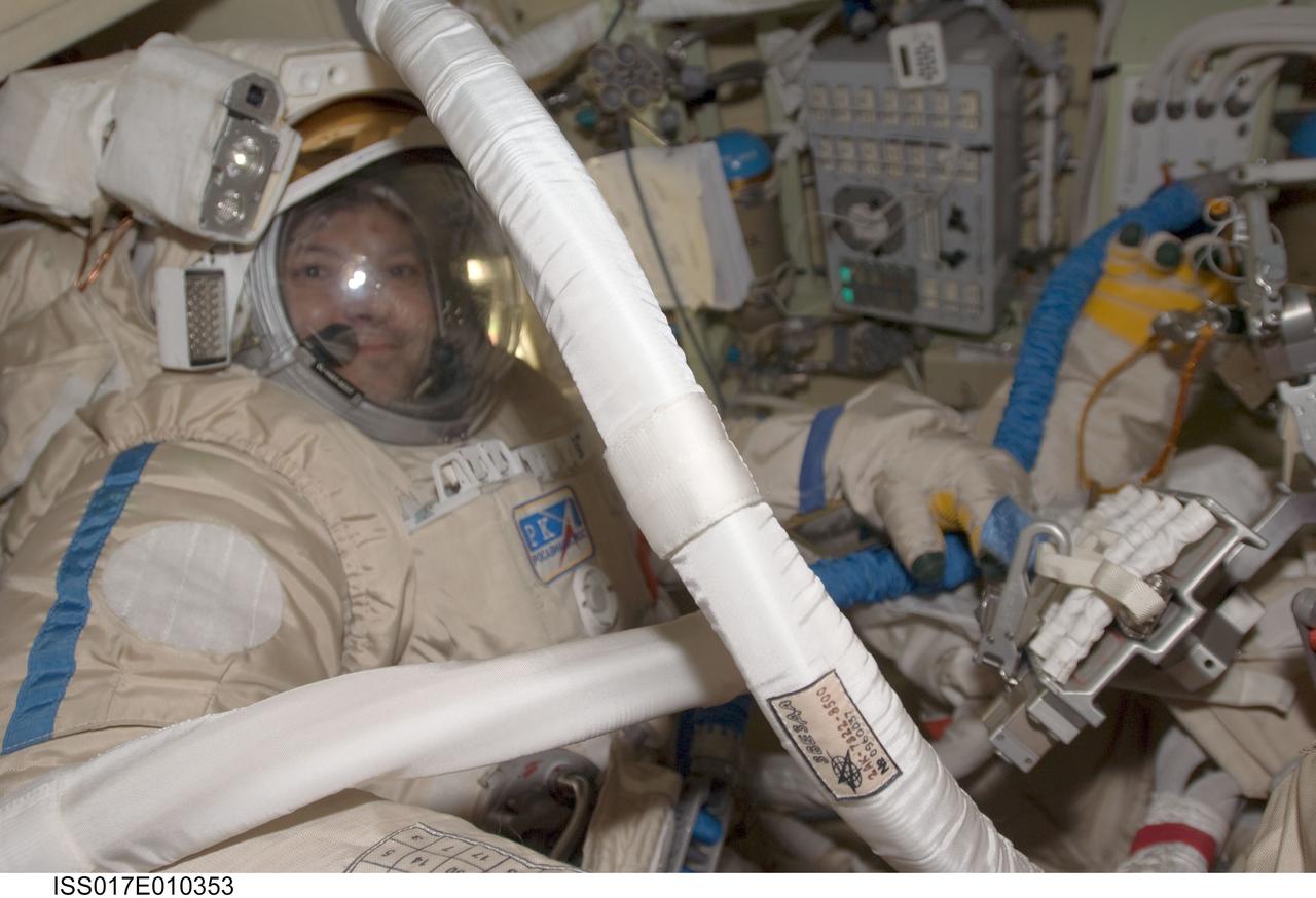 ISS017-E-010353 (8 July 2008) --- Attired in their Russian Orlan spacesuits, Russian Federal Space Agency cosmonauts Sergei Volkov (right, partially out of frame) and Oleg Kononenko, Expedition 17 commander and flight engineer, respectively, prepare for their spacewalk scheduled for July 10. During the full dress rehearsal "dry run", the crewmembers tested translation capability and the status of the suits' communications gear and other systems while in the Pirs Docking Compartment of the International Space Station.