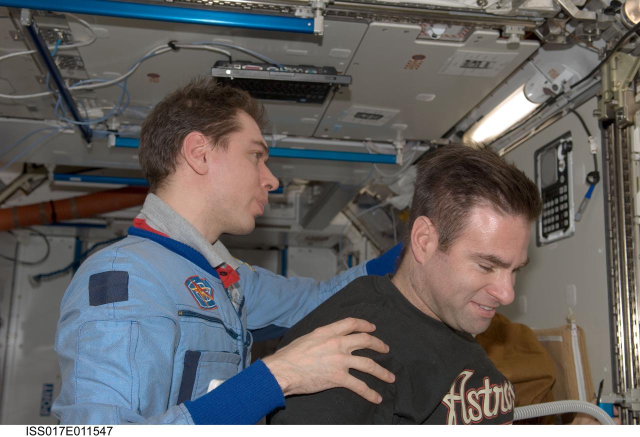 ISS017-E-011547 (20 July 2008) --- Russian Federal Space Agency cosmonaut Sergei Volkov, Expedition 17 commander, trims NASA astronaut Greg Chamitoff's hair in the Harmony node of the International Space Station. Volkov used hair clippers fashioned with a vacuum device to garner freshly cut hair.