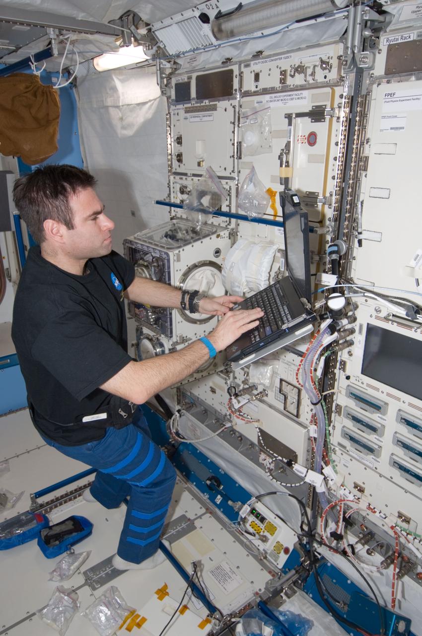 ISS017-E-012001 (30 July 2008) --- NASA astronaut Greg Chamitoff, Expedition 17 flight engineer, uses a computer while working with an experiment in the Kibo laboratory of the International Space Station.