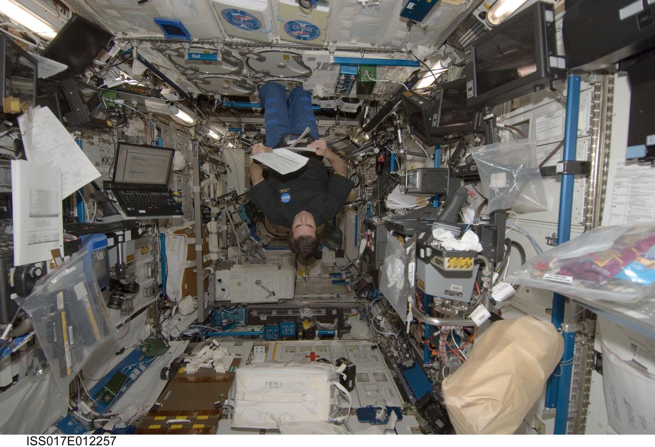 ISS017-E-012257 (16 July 2008) --- NASA astronaut Greg Chamitoff, Expedition 17 flight engineer, looks over a checklist in the Destiny laboratory of the International Space Station.