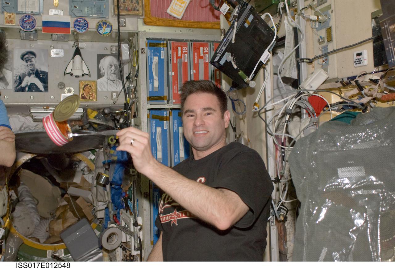 ISS017-E-012548 (28 July 2008) --- NASA astronaut Greg Chamitoff, Expedition 17 flight engineer, prepares to eat a meal near the galley in the Zvezda Service Module of the International Space Station.