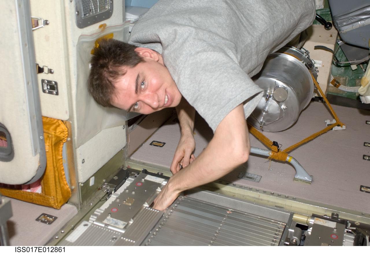 ISS017-E-012861 (12 Aug. 2008) --- Russian Federal Space Agency cosmonaut Sergei Volkov, Expedition 17 commander, performs in-flight maintenance on the Treadmill Vibration Isolation System (TVIS) in the Zvezda Service Module of the International Space Station.