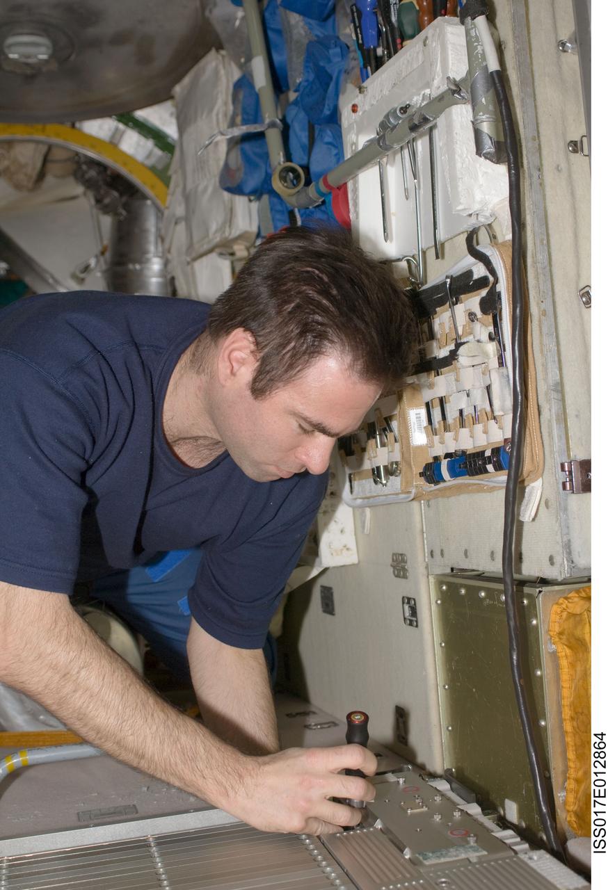 ISS017-E-012864 (12 Aug. 2008) --- NASA astronaut Greg Chamitoff, Expedition 17 flight engineer, performs in-flight maintenance on the Treadmill Vibration Isolation System (TVIS) in the Zvezda Service Module of the International Space Station.