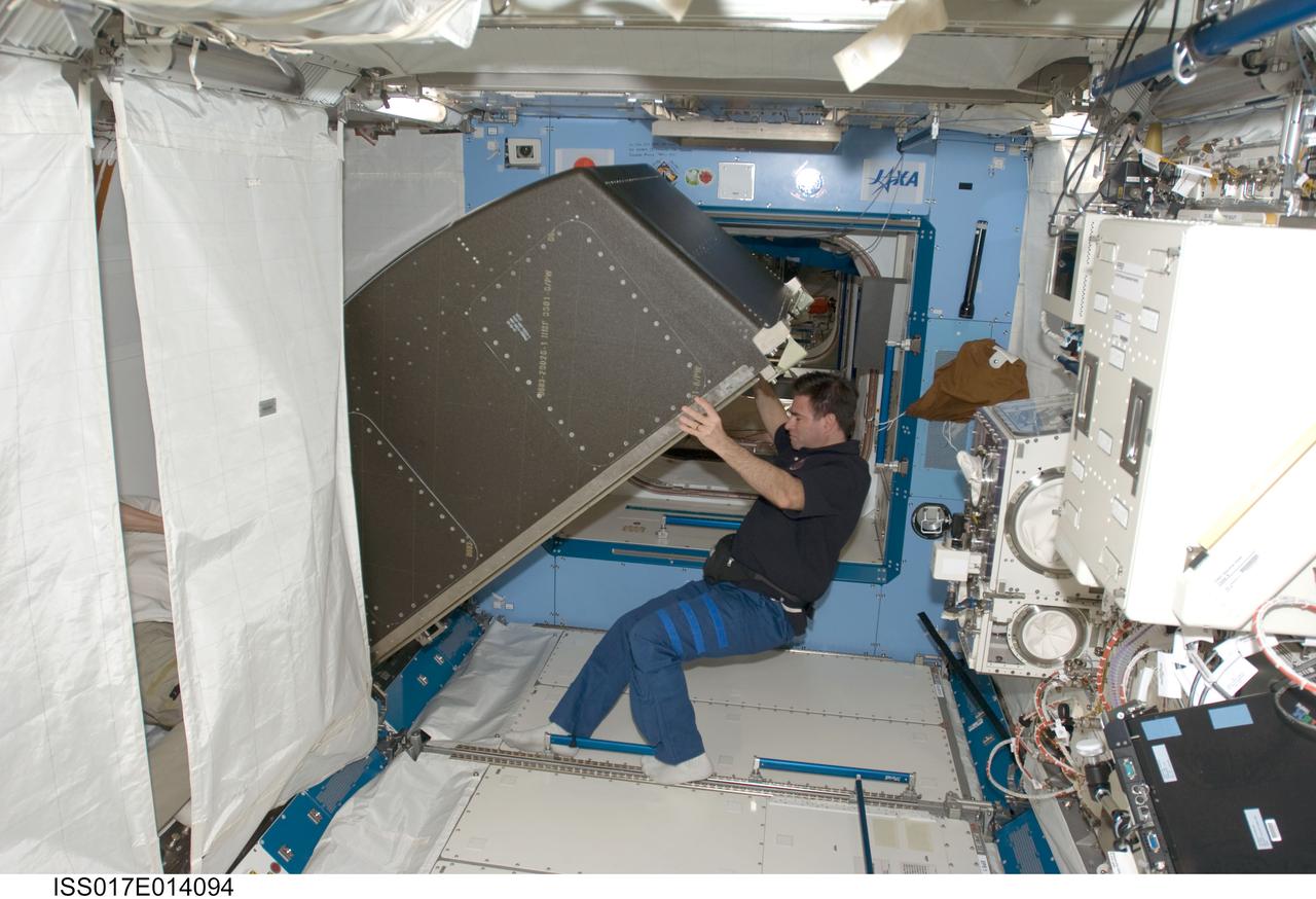 ISS017-E-014094 (26 Aug. 2008) --- Part of the news for the current inhabitants of the International Space Station is that moving day perhaps comes more often in space than on Earth, but the good news is that the weightlessness of space literally lightens the load. Here, in the Kibo laboratory, astronaut Greg Chamitoff, Expedition 17 flight engineer, shares the aid of cosmonaut Sergei Volkov (mostly out of the frame at left), commander, to relocate an experiment rack.