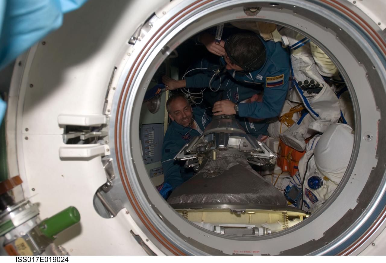 ISS017-E-019024 (14 Oct. 2008) --- Russian Federal Space Agency cosmonaut Yury Lonchakov (top), Expedition 18 flight engineer, and American spaceflight participant Richard Garriott ingress the Earth-facing port of the International Space Station's Zarya module after arriving onboard the Soyuz TMA-13 spacecraft with NASA astronaut Michael Fincke (out of frame), commander. Hatches between the two spacecraft were opened at 4:55 a.m. (CDT).